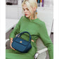 Woman holding a Clare-Rae Bafelli Leather Crossbody Bento Bag Blue